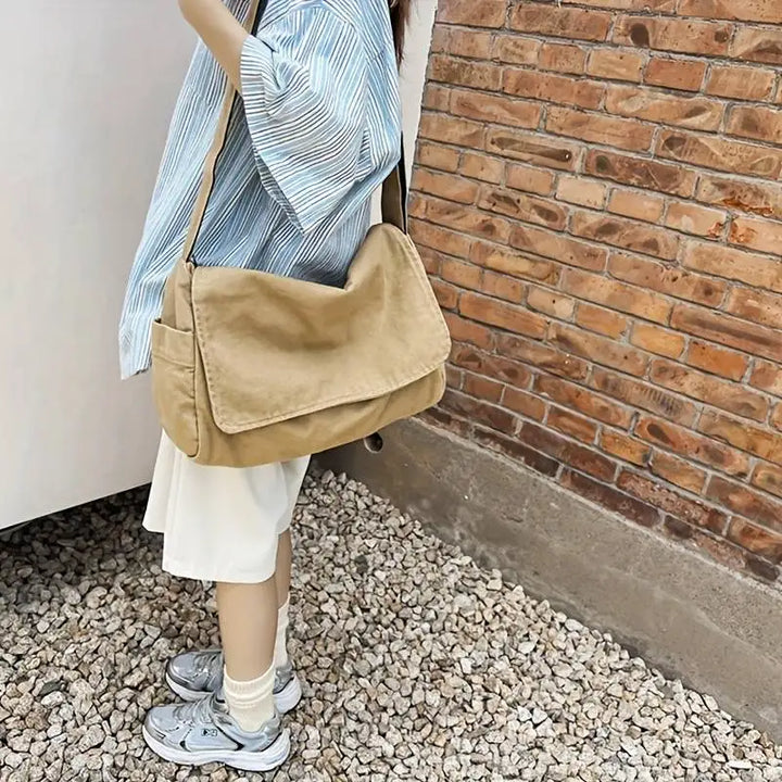Personne portant un sac bandoulière unisexe en tissu écologique, accessoire de mode pour la ville.