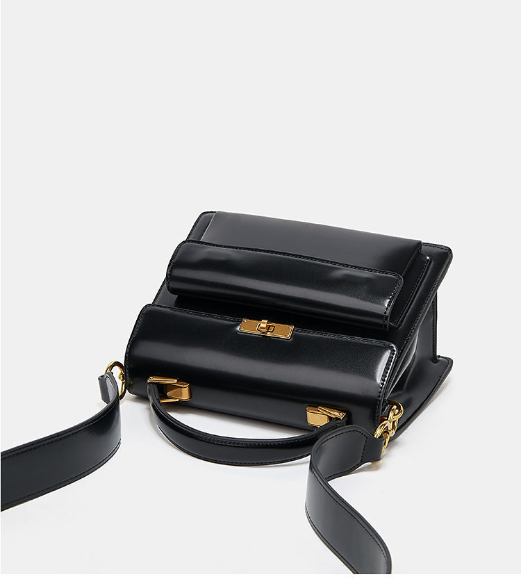 Détail du sac à main vernis noir, bandoulière fine et finition brillante, accessoire mode femme.