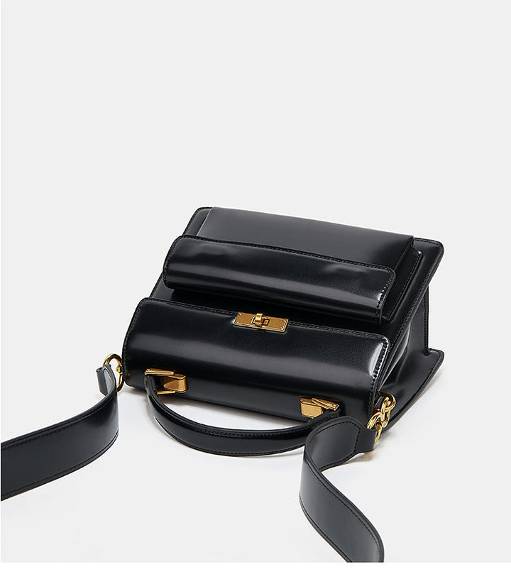 Détail du sac à main vernis noir, bandoulière fine et finition brillante, accessoire mode femme.