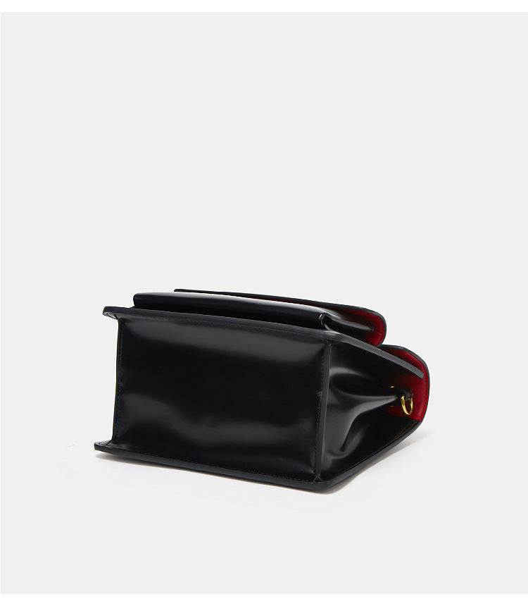 Accessoire de mode femme : sac à bandoulière en similicuir vernis noir, élégance intemporelle.