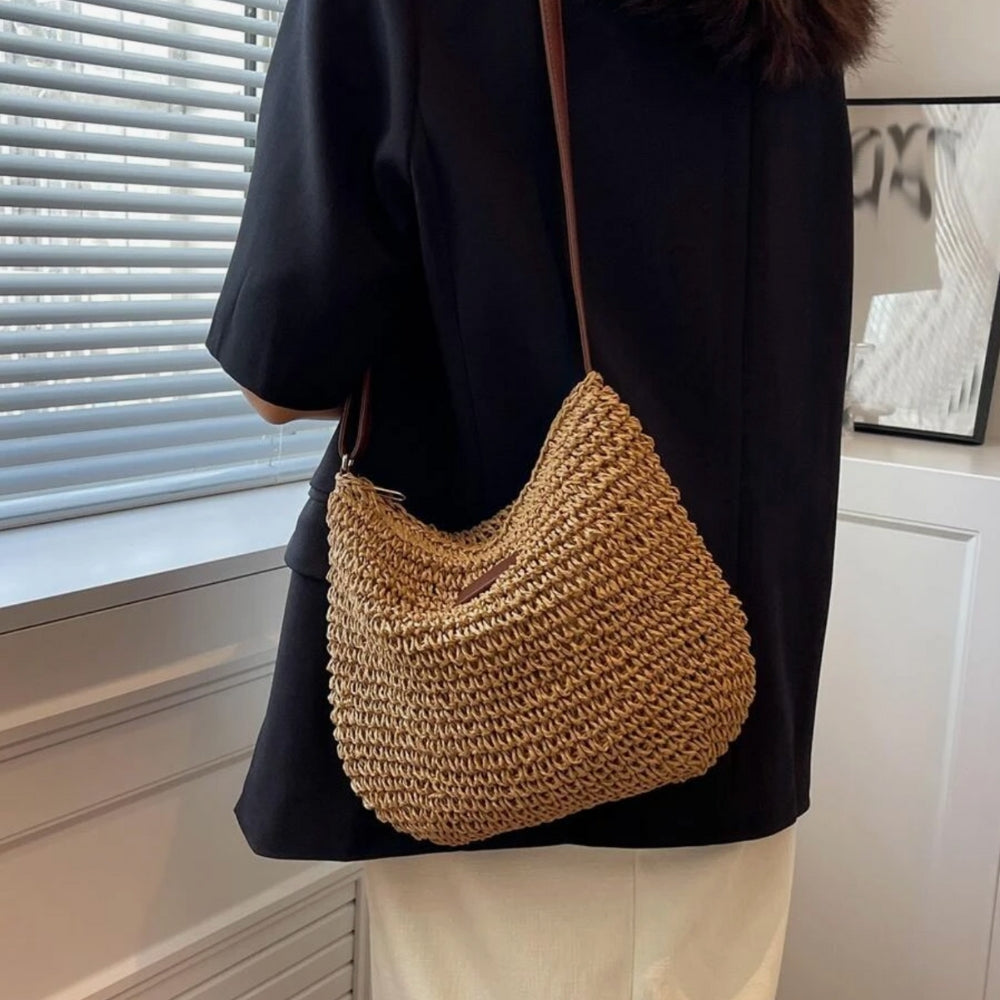 "Sac bandoulière Léandre en paille premium avec finitions cuir végan, bandoulière ajustable et fermeture éclair sécurisée."