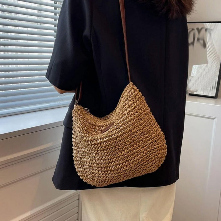"Sac bandoulière Léandre en paille premium avec finitions cuir végan, bandoulière ajustable et fermeture éclair sécurisée."