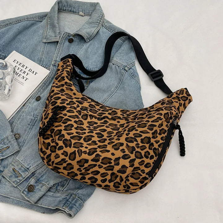 Sac besace femme léopard en toile, bandoulière ajustable, accessoire mode tendance.