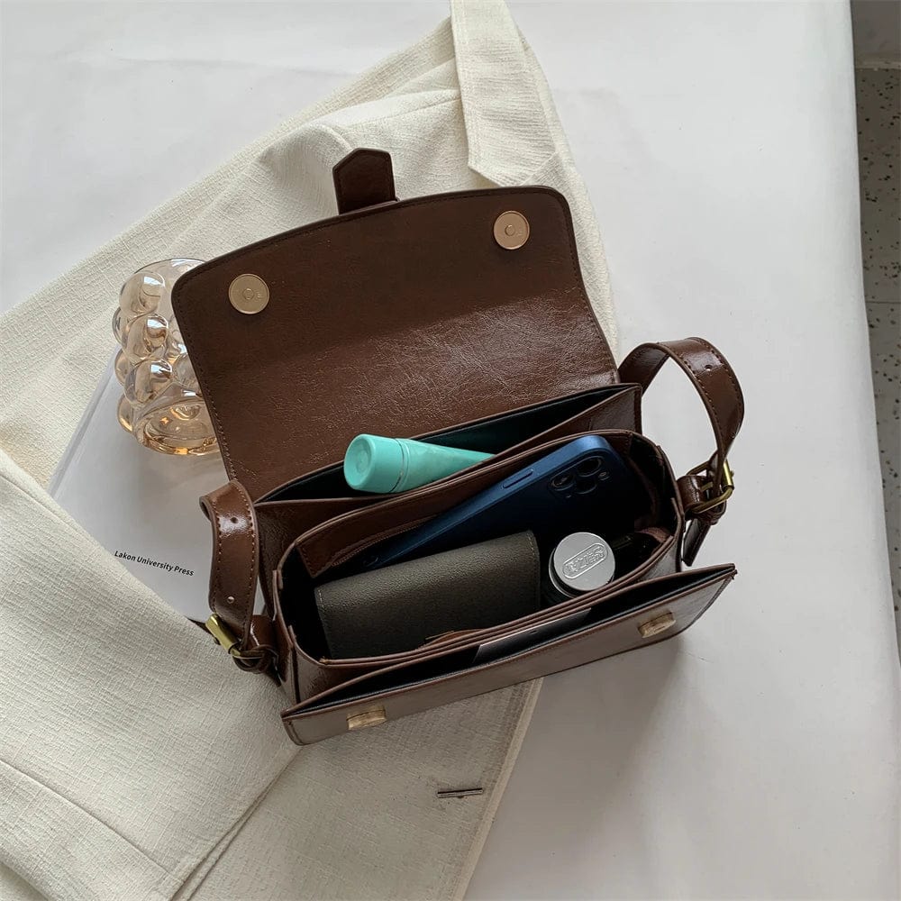 Détail du fermoir doré sur sac besace femme en cuir PU noir, style élégant