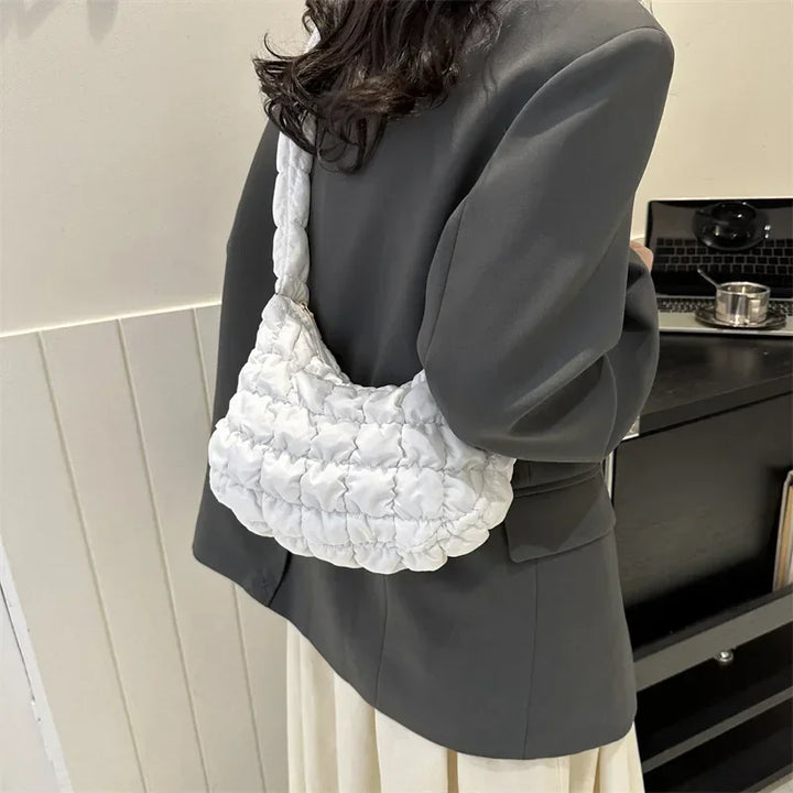Intérieur spacieux d'un sac besace femme matelassé, doublure unie et poches pratiques