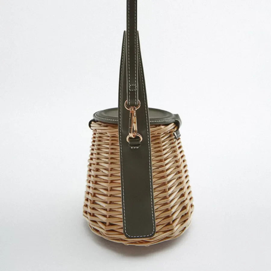 Sac d'été en paille naturelle avec fermeture à cordon style bourse et finitions vert foncé pour femme.