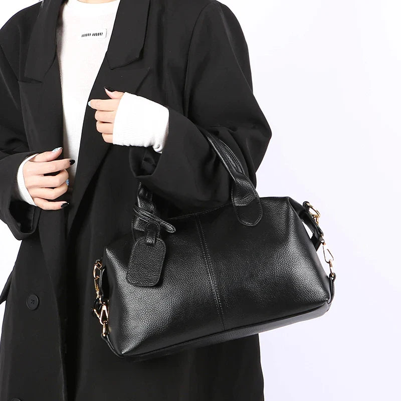 Sac bowling noir élégant en similicuir pour femme, accessoire de mode chic avec bandoulière réglable.