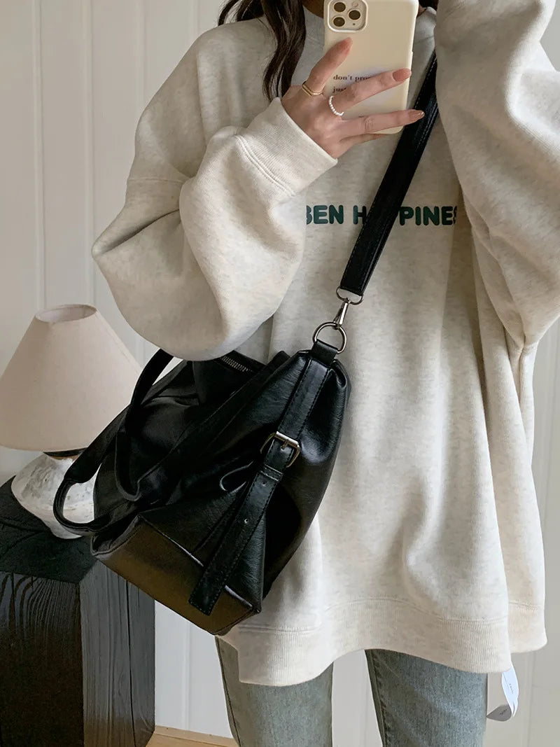 Sac bandoulière femme noir en similicuir, style cabas, pratique et élégant, pour un look mode quotidien.