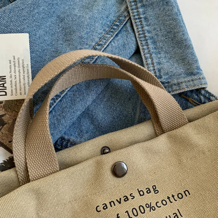 Sac cabas en toile beige, style décontracté, avec bandoulière amovible, parfait comme fourre-tout quotidien.