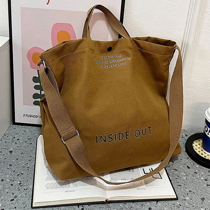Élégant sac cabas en toile noire, porté épaule ou bandoulière, grand espace de rangement pour tous vos besoins.