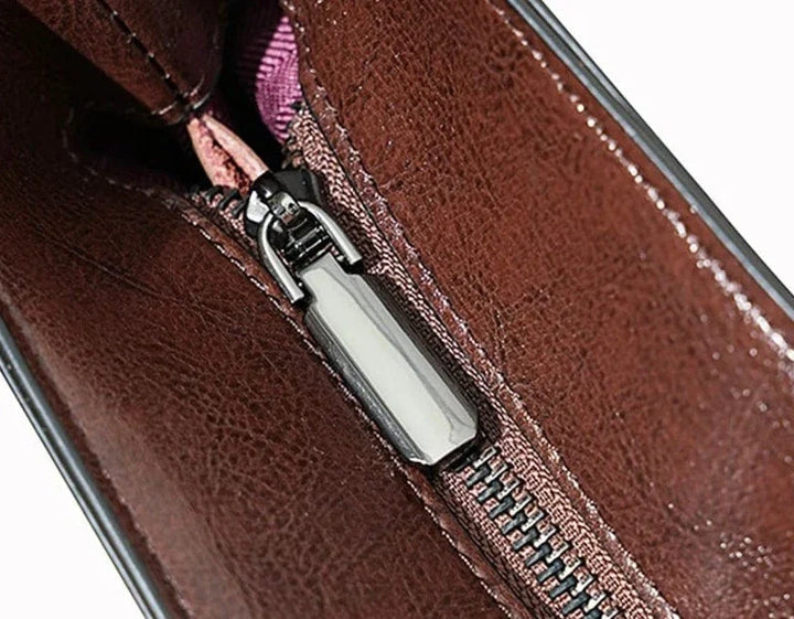 Gros plan sur la texture du cuir véritable d'un sac cabas femme, détail des coutures et quincaillerie.