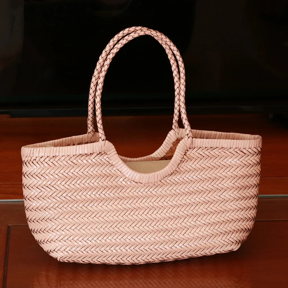 Femme élégante portant un sac cabas en cuir tressé à l'épaule, style quotidien.