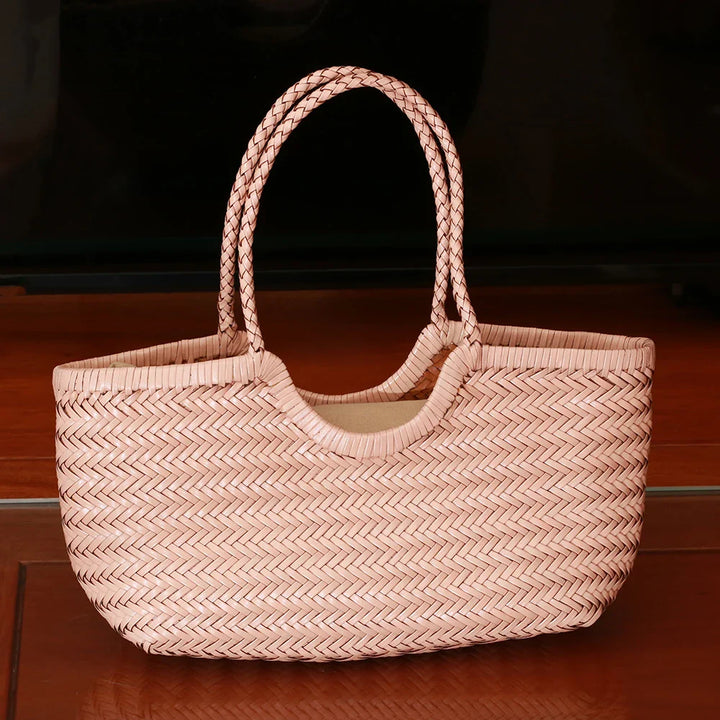 Femme élégante portant un sac cabas en cuir tressé à l'épaule, style quotidien.