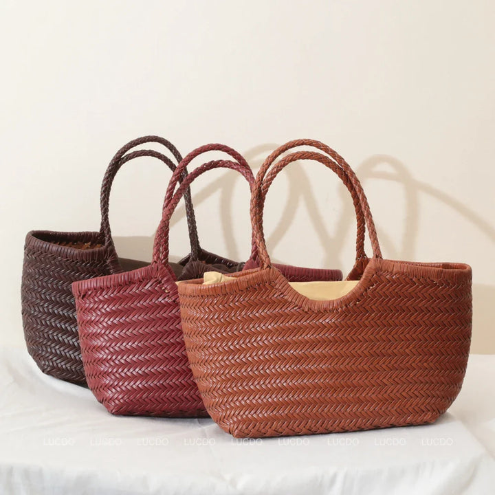 Détail des anses et de la bandoulière d'un sac cabas en cuir tressé, porté épaule confortable.
