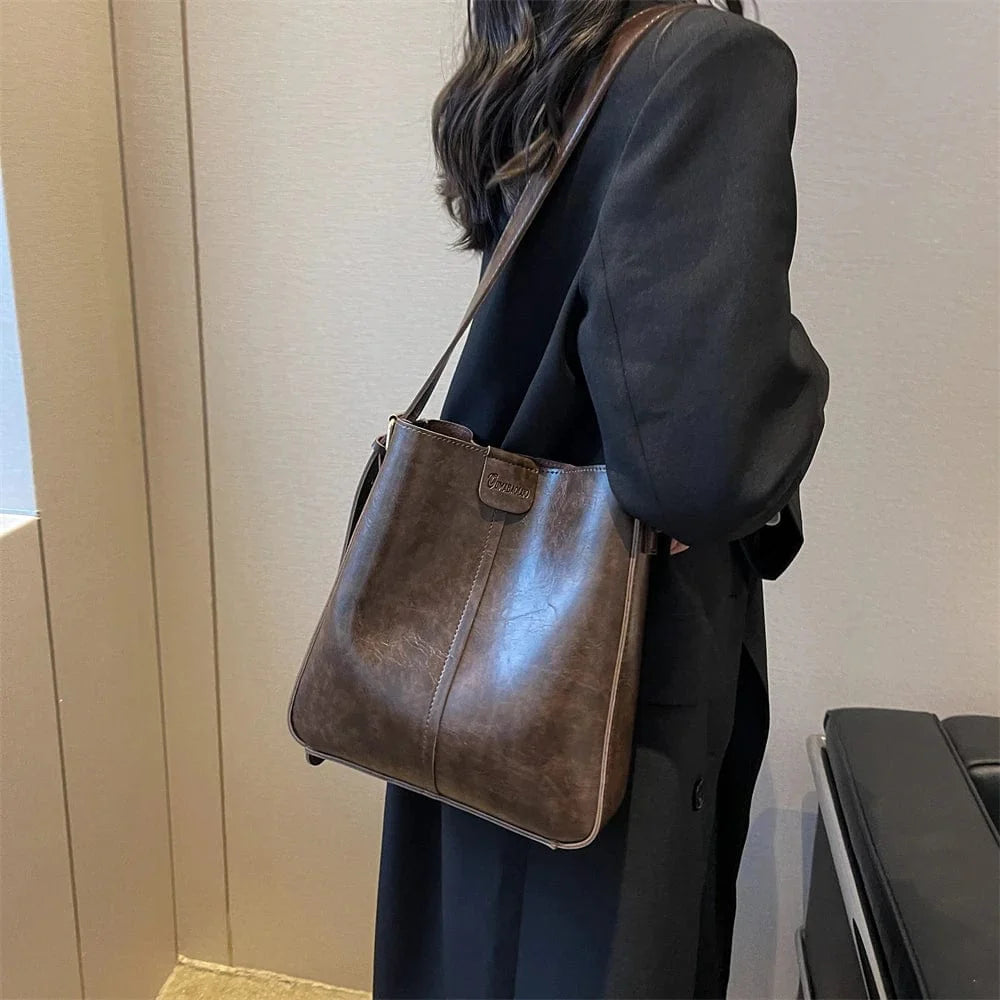 Sac épaule pratique en cuir vegan camel, avec fermeture sécurisée et bandoulière pour un transport facile.