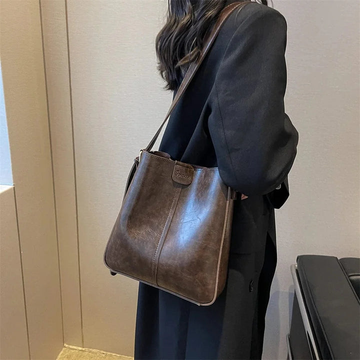 Sac épaule pratique en cuir vegan camel, avec fermeture sécurisée et bandoulière pour un transport facile.