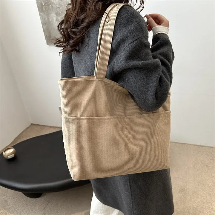 Élégant sac cabas femme en velours beige, style fourre-tout pratique avec bandoulière, parfait mode hiver.