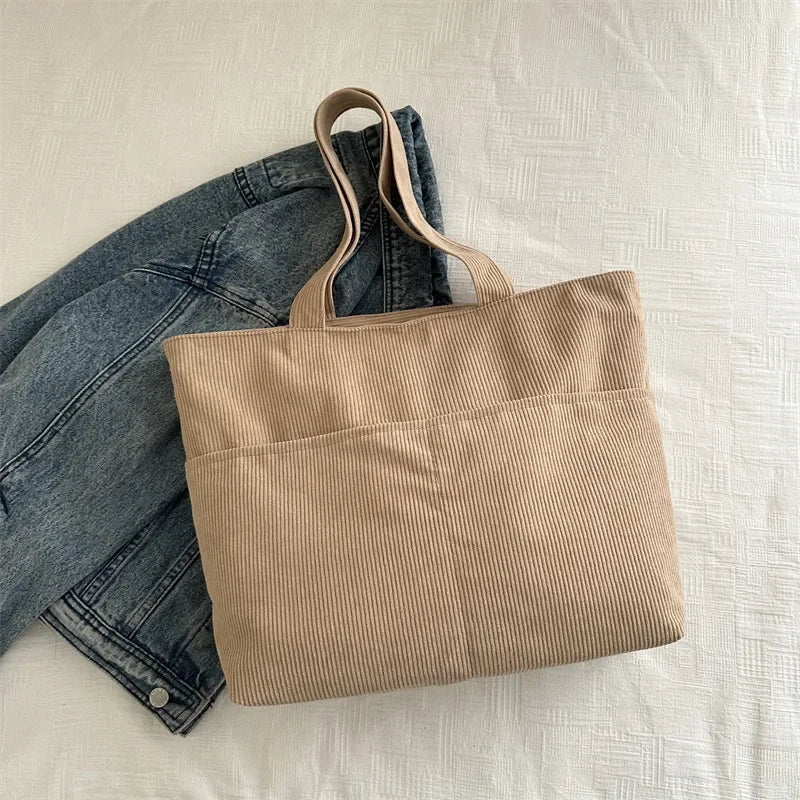 Sac cabas femme gris en velours doux, avec bandoulière. Élégance et confort pour le quotidien urbain.