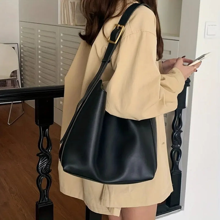 Femme portant un sac cabas élégant en simili cuir, comme sac à bandoulière. Confort et style quotidien.