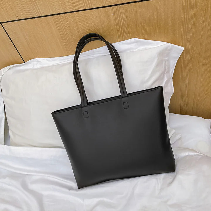 Sac cabas femme élégant en similicuir noir, idéal pour lycéenne ou étudiante. Design fonctionnel et chic.