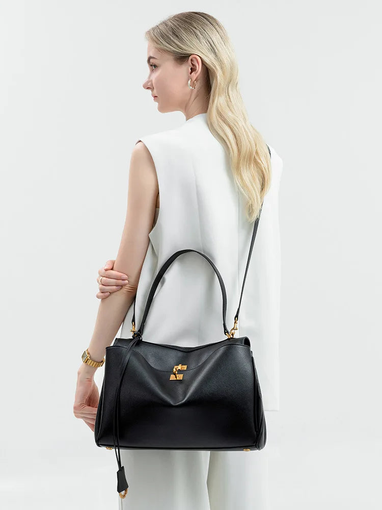 Sac cabas femme noir sur table, soulignant son allure chic et sa polyvalence pour diverses occasions.