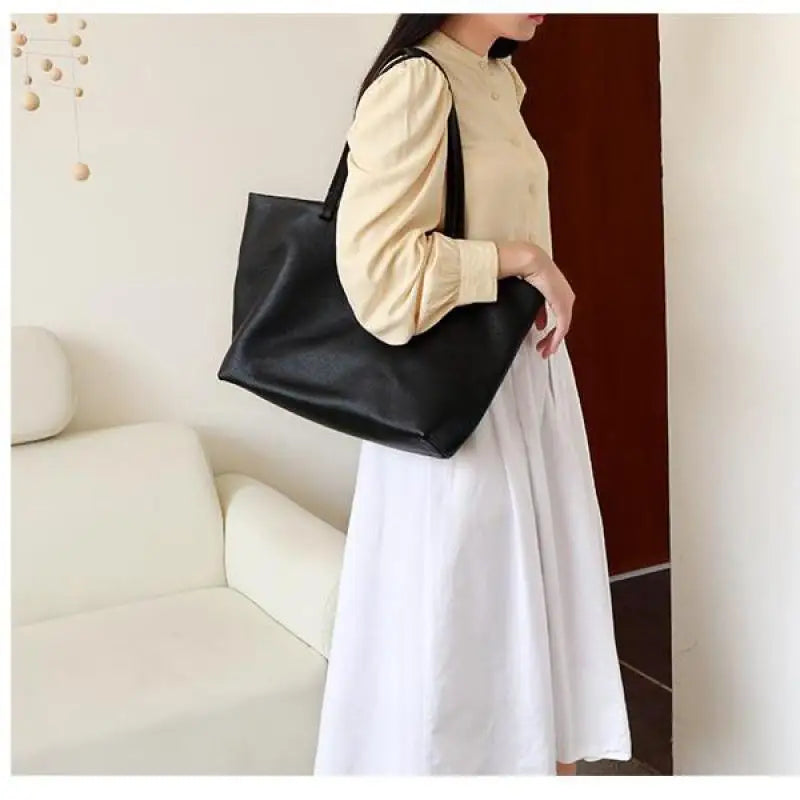 Sac cabas noir spureux en cuir grainé pour femme, conçu pour un usage quotidien chic et pratique.