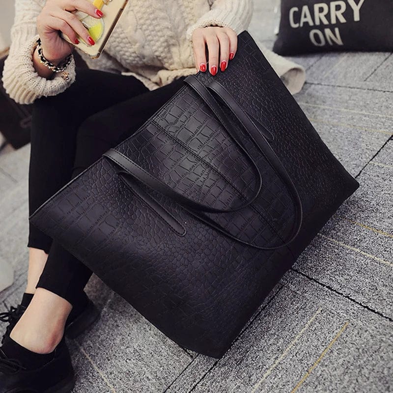 Sac cabas élégant en cuir vegan noir avec motif alligator, porté épaule par femme