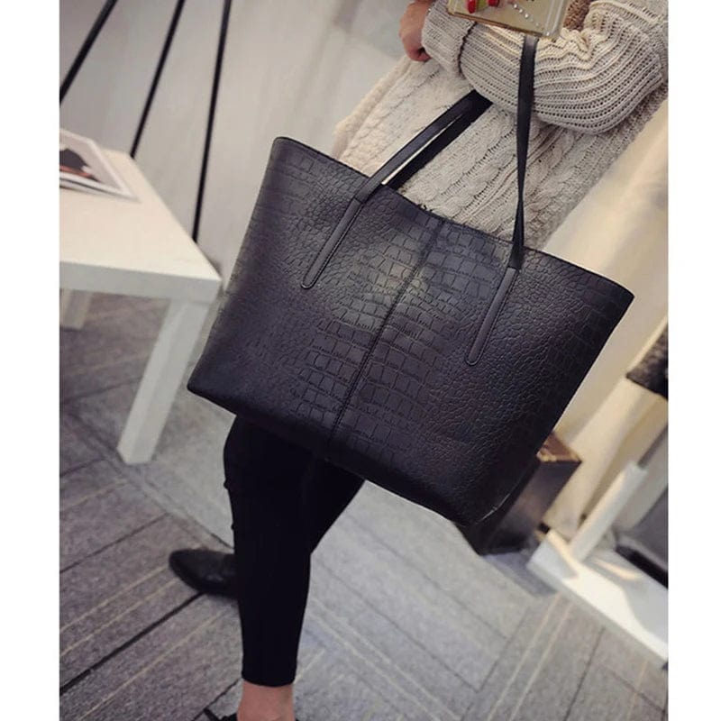 Fermeture éclair dorée et breloque chic sur sac cabas femme en cuir vegan noir