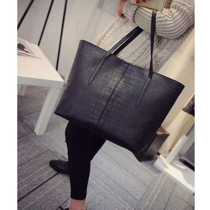 Fermeture éclair dorée et breloque chic sur sac cabas femme en cuir vegan noir