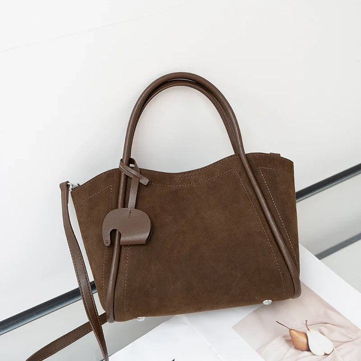 Gros plan sur la texture du daim synthétique d'un sac cabas élégant femme, couleur marron.