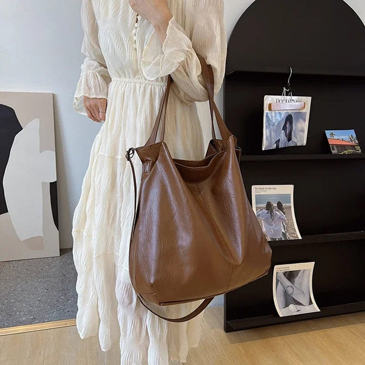 Sac cabas en cuir vegan beige, posé sur une table en bois, lumière naturelle