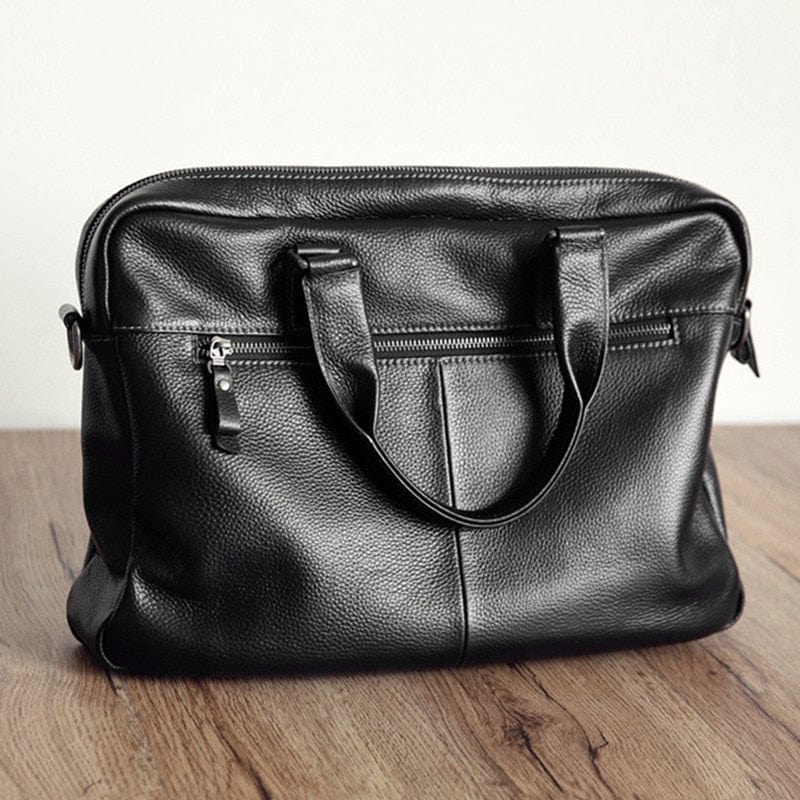 Sac professionnel homme Noam en cuir véritable noir, avec poignée supérieure et bandoulière amovible.