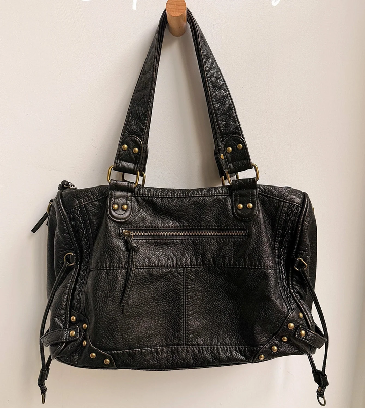 Sac cabas femme noir, porté à l'épaule, montrant sa capacité et son style polyvalent pour la vie quotidienne