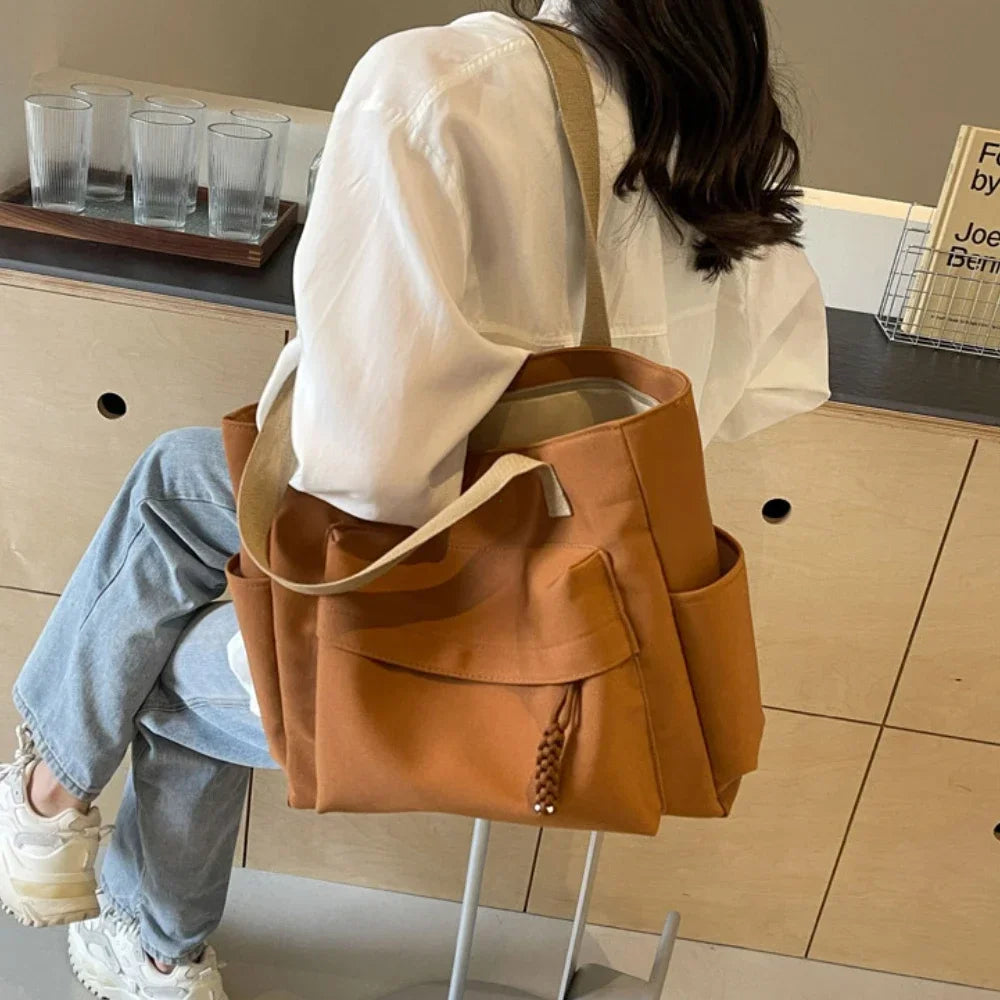 Sac d'épaule noir pour étudiante. Grand sac de cours avec compartiments pour une organisation optimale et stylée.