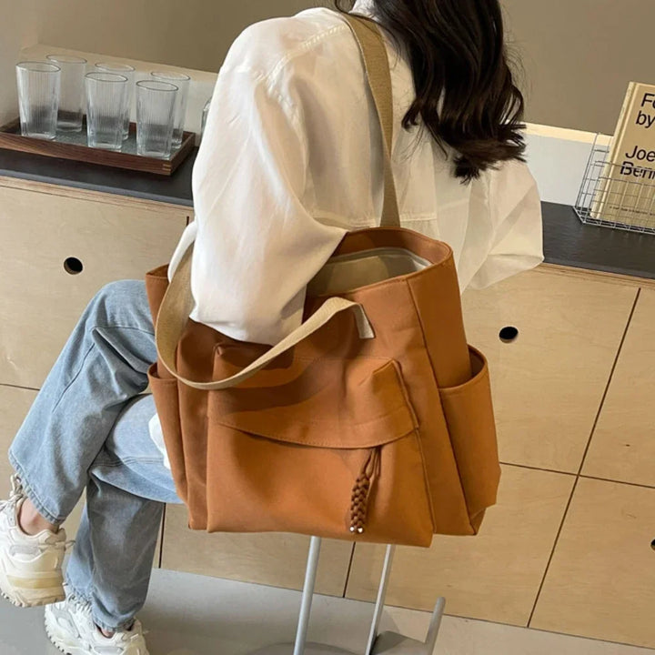 Sac d'épaule noir pour étudiante. Grand sac de cours avec compartiments pour une organisation optimale et stylée.