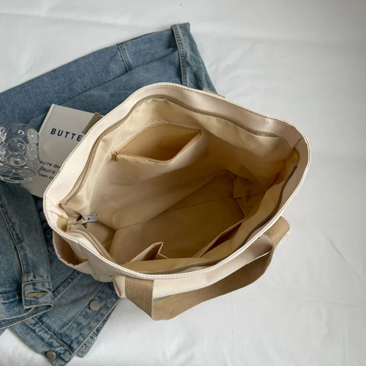 Chic sac de cours beige/crème pour femme en toile. Spacieux et tendance, idéal pour études ou usage quotidien.