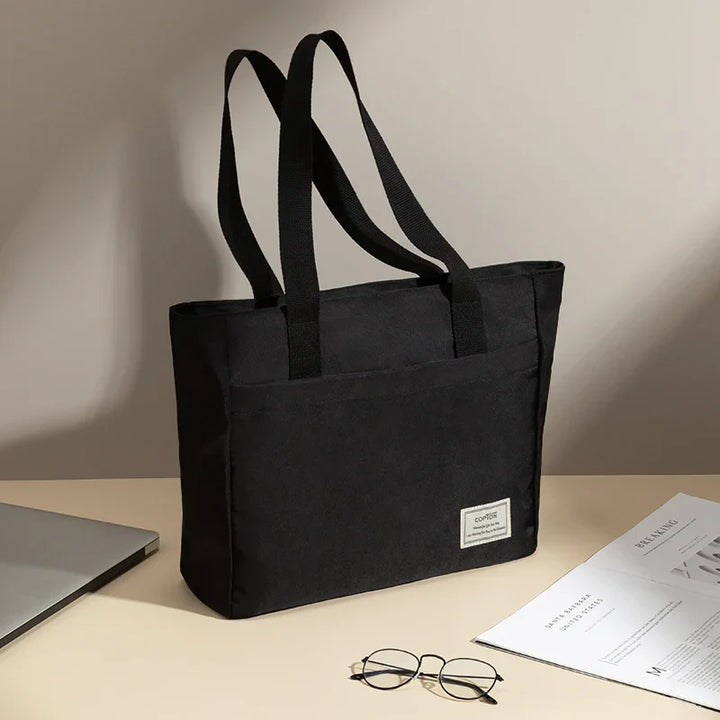 Sac femme étudiant organisé, en toile imperméable, pour transporter cours et ordinateur avec style.