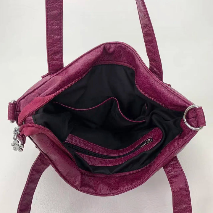 Sac femme élégant noir pour cours et quotidien, en similicuir, avec poignées et sangle ajustable.