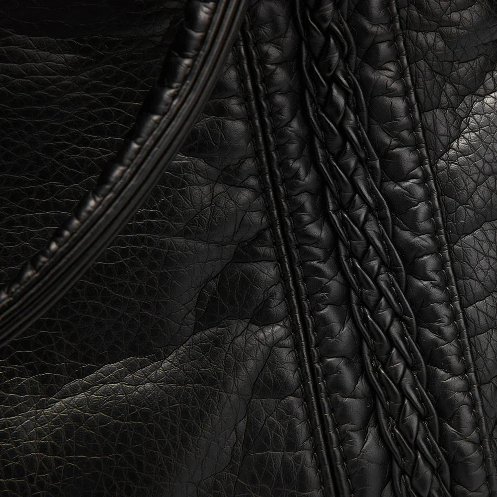Sac à épaule vintage marron complétant une tenue rétro chic de femme, parfait pour les cours.
