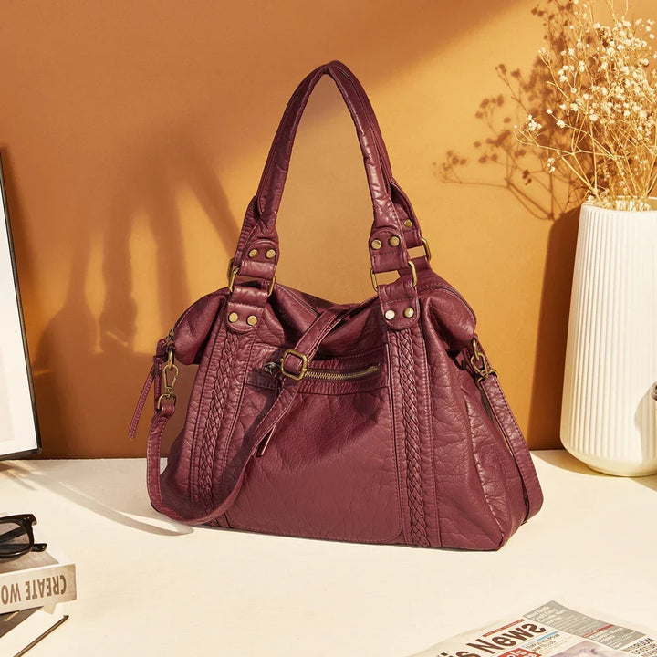 Femme lisant avec un sac de cours vintage posé à côté dans un café, ambiance rétro, sac femme.