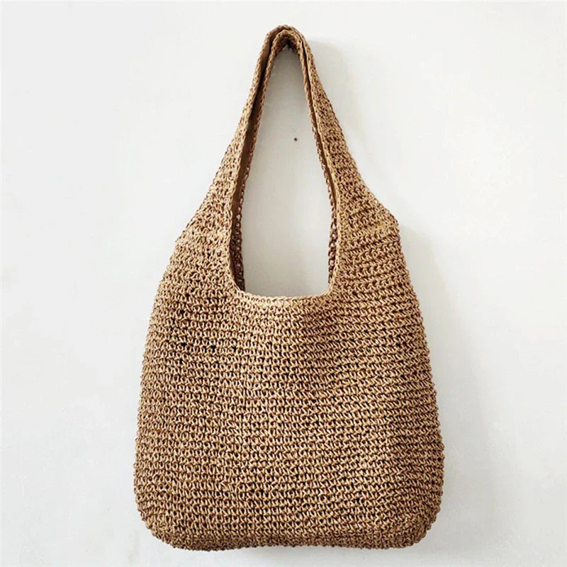 Sac de plage chic pour femme en paille tressée, idéal pour l'été et les vacances en bord de mer.