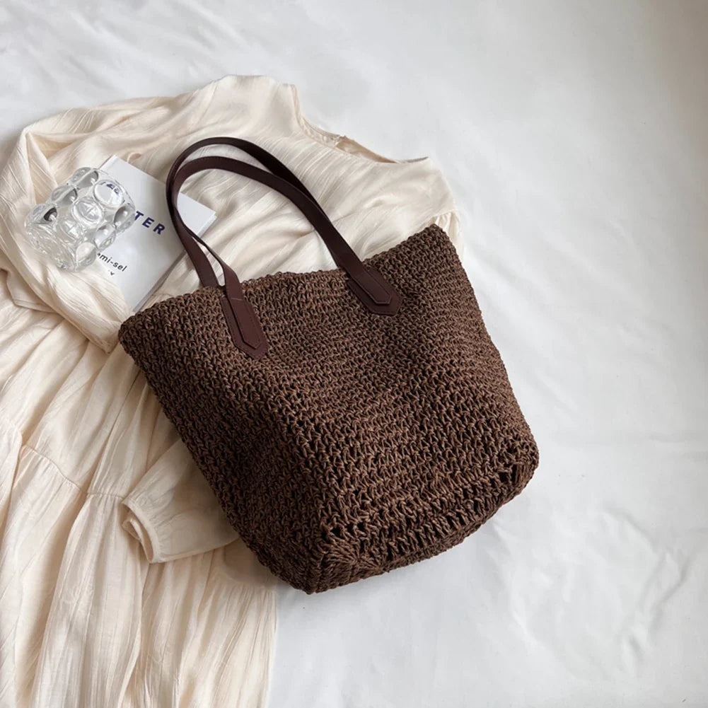 Sac de plage en paille naturelle porté par une femme, accessoire léger pour un look estival.