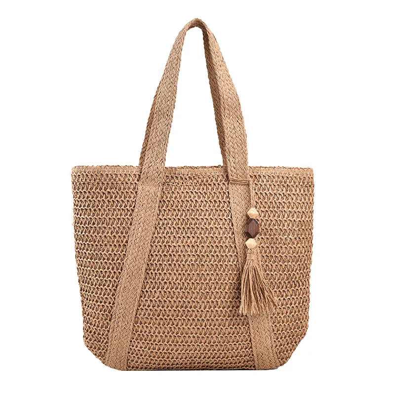 Sac de plage femme chic et spacieux en paille et coton, parfait pour une journée d'été en bord de mer.