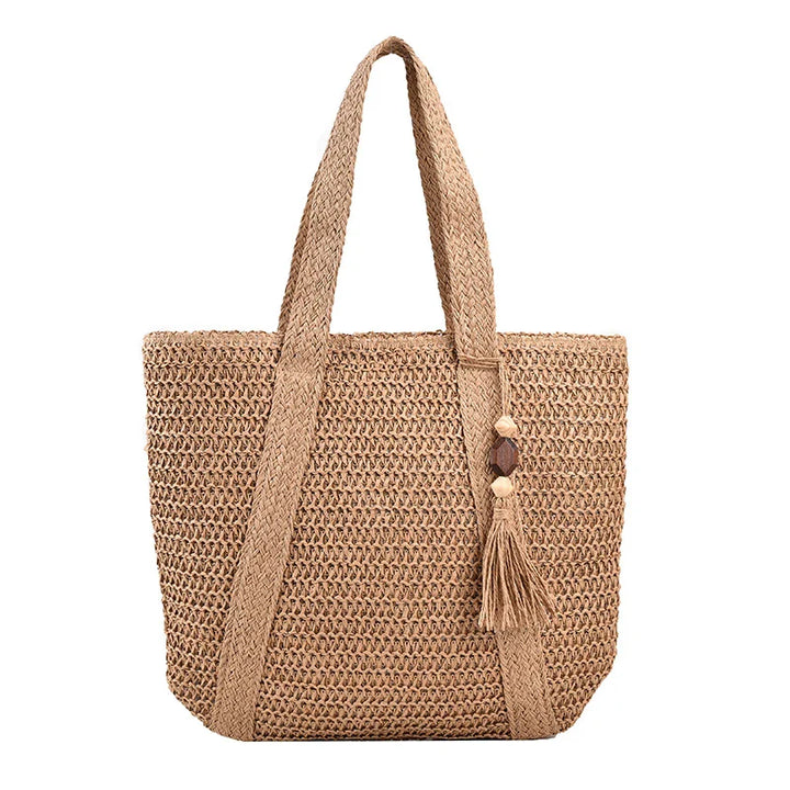 Sac de plage femme chic et spacieux en paille et coton, parfait pour une journée d'été en bord de mer.