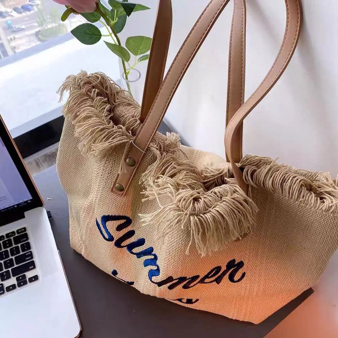 Sac de plage en toile de coton avec franges, accessoire féminin et mode pour des vacances réussies.