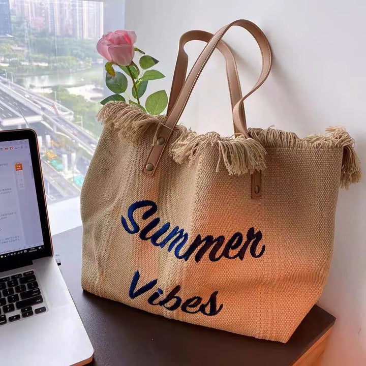 Élégant sac cabas de plage pour femme, en toile résistante avec de jolies franges, pour un look estival.