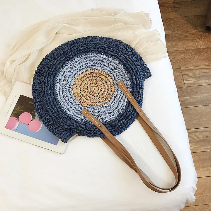 Sac de plage femme moderne et élégant, rond en paille naturelle, idéal pour vos escapades estivales.