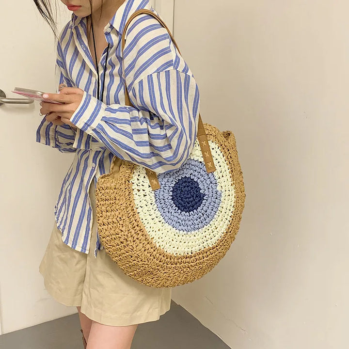 Sac de plage rond en paille, pratique et bohème chic, l'accessoire indispensable pour vos journées d'été.