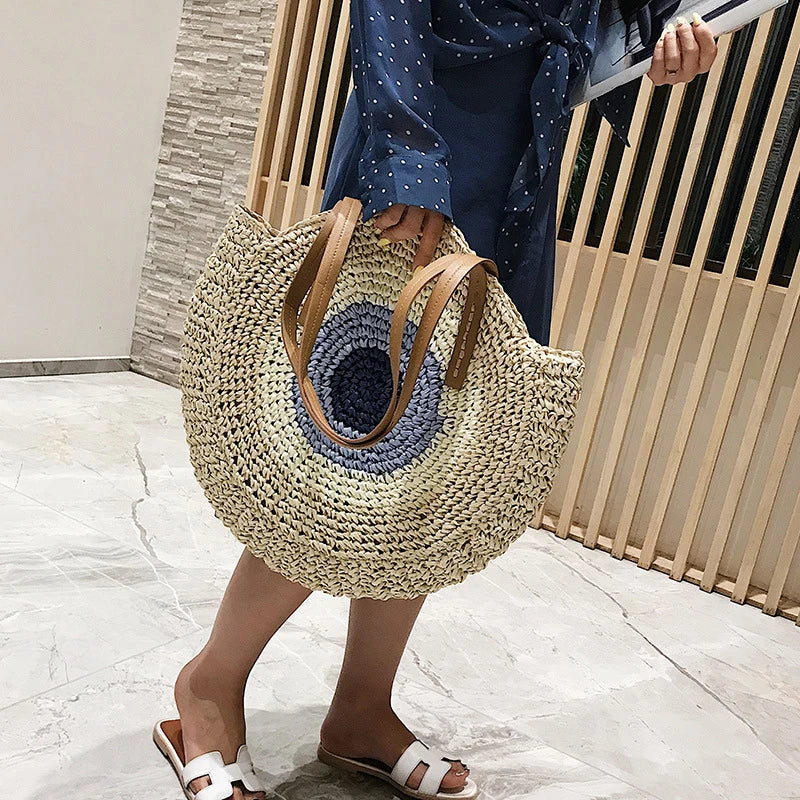 Sac épaule femme en paille ronde, style bohème pour un look estival élégant et décontracté.