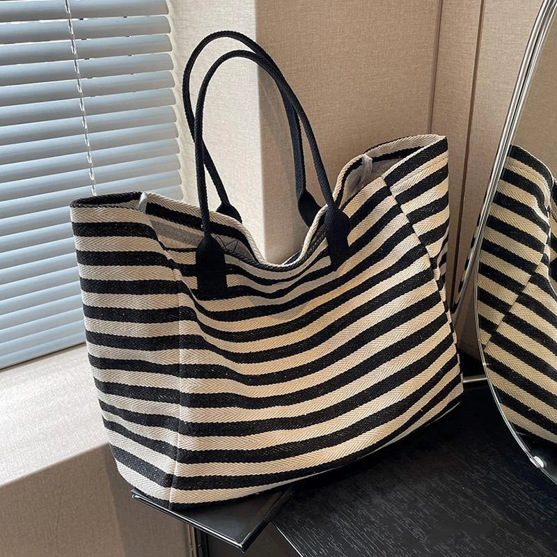 Sac de plage XL marinière élégant pour femme, rayé noir et blanc en toile, idéal été et vacances.